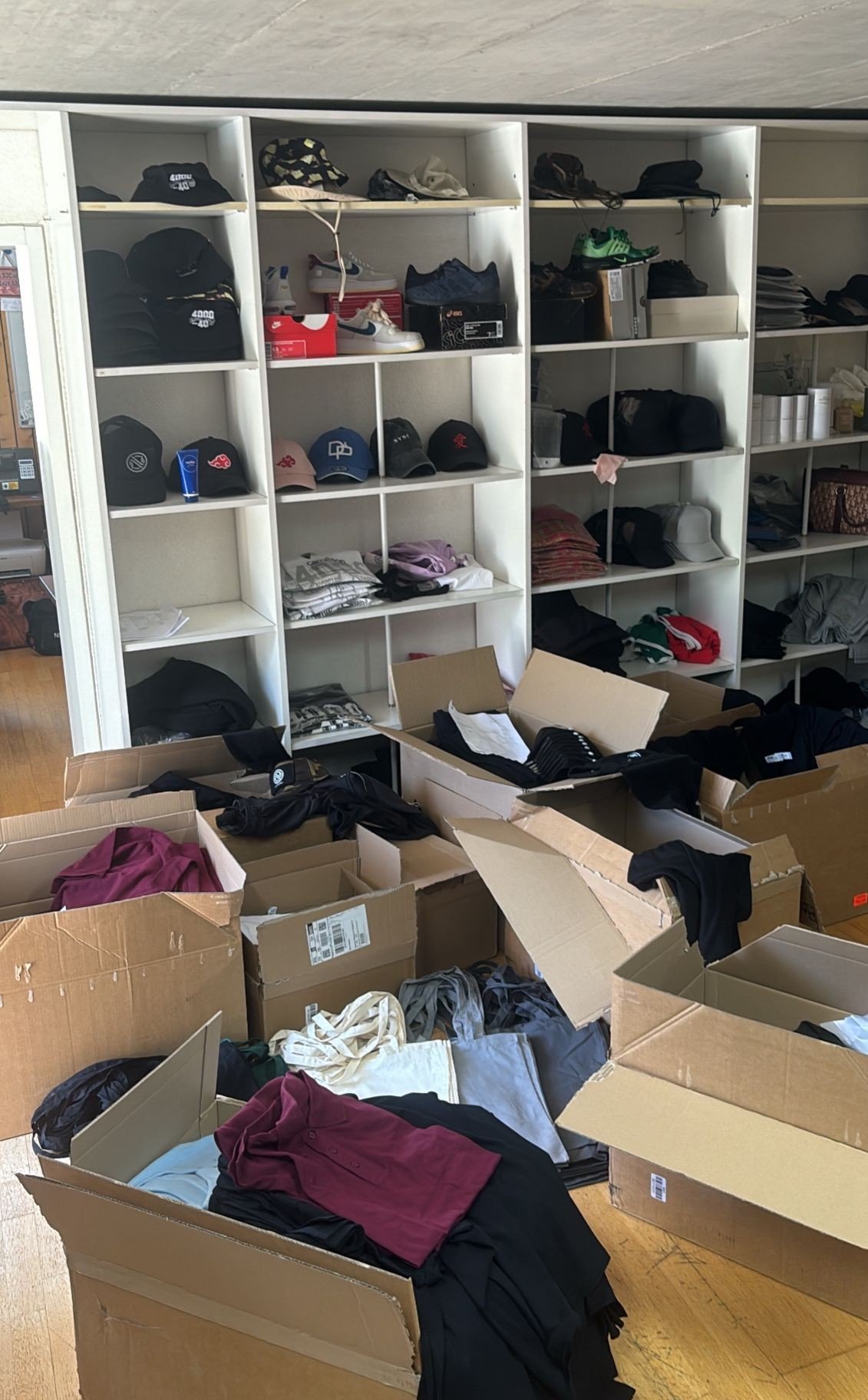 Atelier NVNC à Sierre — étagères de stock textile et cartons de production en cours